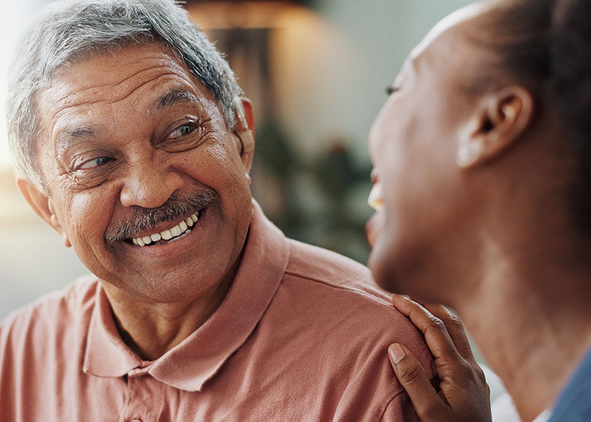 Nurse and elderly man talking and smiling. Elderly care and long-term care planning.